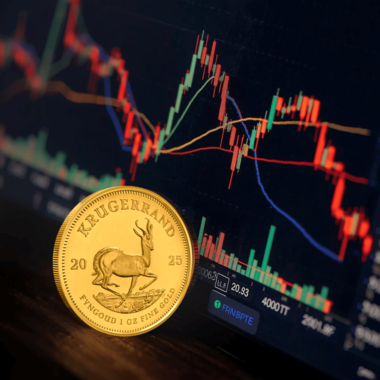Krugerrand with live gold trading charts showing volatility, highlighting differences between physical and paper gold.
