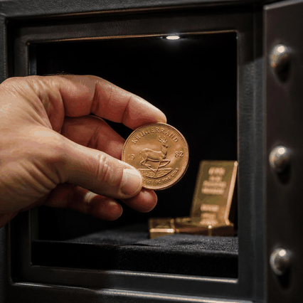 Investor storing a physical Krugerrand coin in a safe, a key difference between gold coins and gold ETFs